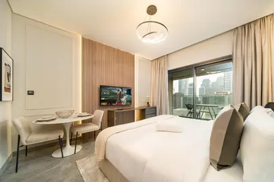 a hotel room with a large bed and a table at Stylish Modern Peninsula One Studio, Business Bay in Dubai