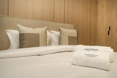 a bed with white sheets and pillows in a room at Stylish Modern Peninsula One Studio, Business Bay in Dubai