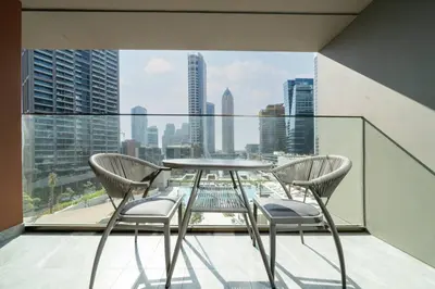 a glass table and chairs on a balcony with a view at Stylish Modern Peninsula One Studio, Business Bay in Dubai
