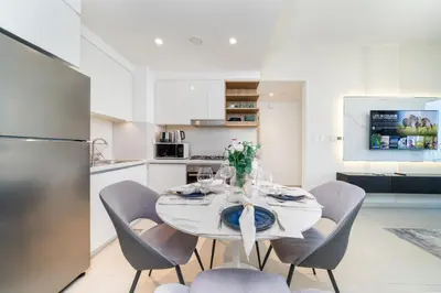 a kitchen and dining room with a white table and chairs at Stylish 1 Bed in Downtown with Dubai Mall Access in Dubai
