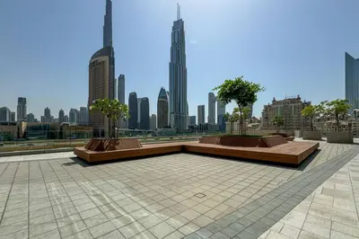 a park with benches and trees in a city at Stylish 1 Bed in Downtown with Dubai Mall Access in Dubai