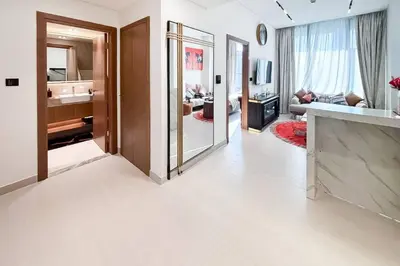 a living room with a large mirror and a bathroom at Modern Place - Trillionaire Residence 608 in Dubai