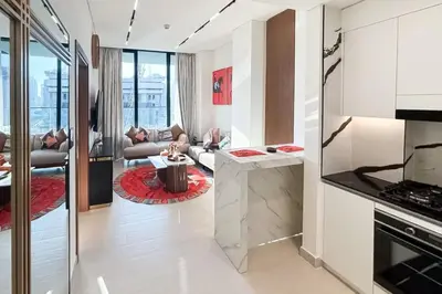 a kitchen and living room with a couch and a table at Modern Place - Trillionaire Residence 608 in Dubai
