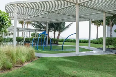 a playground under a pavilion with palm trees at Modern 2BDR in Bluewaters Beach&Pool in Dubai