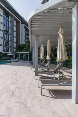 a row of chairs with umbrellas next to a building at Modern 2BDR in Bluewaters Beach&Pool in Dubai