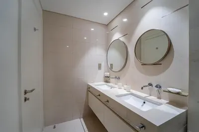 a bathroom with two sinks and two mirrors at 2BR with Atlantis View, Beach Access, and Infinity Pool in Dubai
