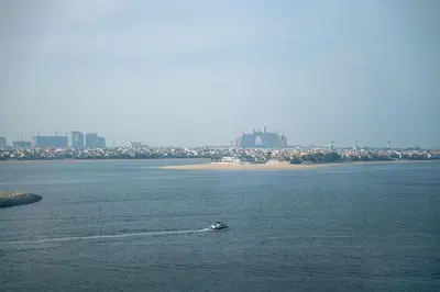 a small boat in a large body of water at 2BR with Atlantis View, Beach Access, and Infinity Pool in Dubai