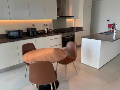 a kitchen with a wooden table and chairs at Marina Gate, Full Marina View, Excellent Location, Dubai Marina in Dubai Marina