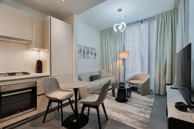 a kitchen and living room with a table and chairs at Stylish Flat in Dubai in Dubai