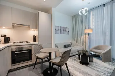 a kitchen and living room with a couch and a table at Stylish Flat in Dubai in Dubai