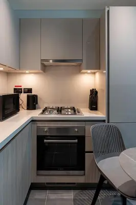 a kitchen with a stove and a sink and a table at Stylish Flat in Dubai in Dubai