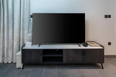 a flat screen tv sitting on top of a entertainment center at Stylish Flat in Dubai in Dubai