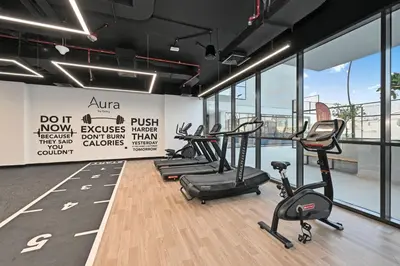 a gym with treadmills and elliptical machines at Aura by Grovy 405 - Parking, Pool&Gym - by Rentujemy in Dubai