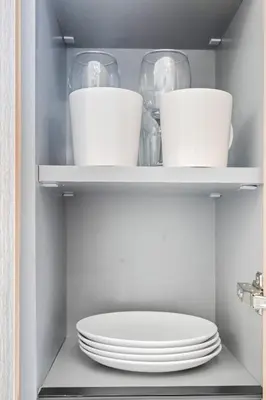 a stack of plates and bowls on a shelf in a refrigerator at Aura by Grovy 405 - Parking, Pool&Gym - by Rentujemy in Dubai