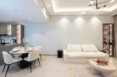 a living room with a table and a couch at Venetian - Elegant 1BR in JVC & Perfect for Work Leisure in Dubai