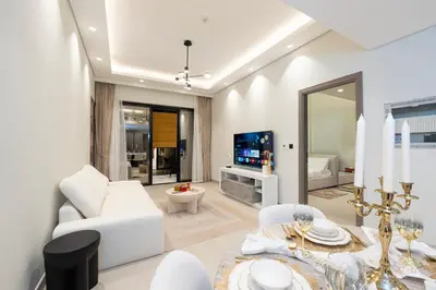 a living room with a dining table and a television at Venetian - Elegant 1BR in JVC & Perfect for Work Leisure in Dubai