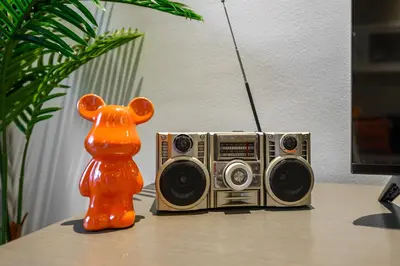 an orange bear figurine next to a radio on a table at Luxury Apartment with canal view - near to Burj Khalifa - Dubai in Dubai