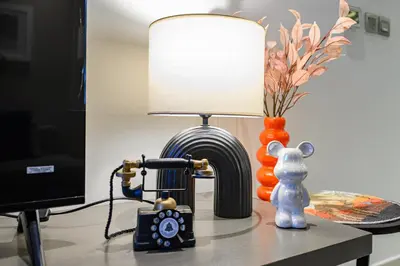 a lamp on a table with a camera and a vase at Luxury Apartment with canal view - near to Burj Khalifa - Dubai in Dubai