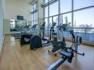 a gym with a row of treadmills and exercise bikes at Burj, Canal & Dubai Mall Luxe Stay for 6 in Dubai