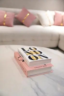 two books sitting on a table in front of a couch at Marina View 2BHK Luxury in Dubai