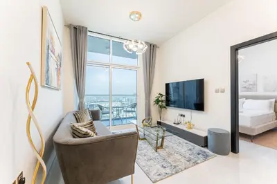 a living room with a couch and a tv at HAVN - 1 Bedroom in Skyz, 5 mins to Miracle Garden in Dubai