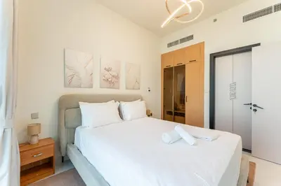 a bedroom with a large white bed with white pillows at HAVN - 1 Bedroom in Skyz, 5 mins to Miracle Garden in Dubai