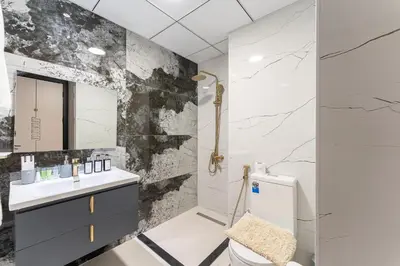 a bathroom with a black and white marble wall at HAVN - 1 Bedroom in Skyz, 5 mins to Miracle Garden in Dubai