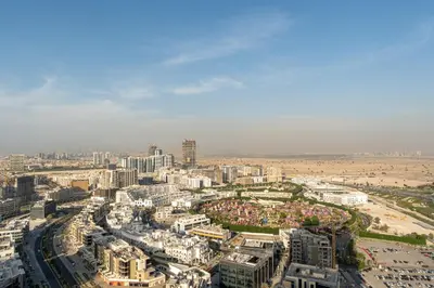 an aerial view of a city with buildings and a beach at HAVN - 1 Bedroom in Skyz, 5 mins to Miracle Garden in Dubai