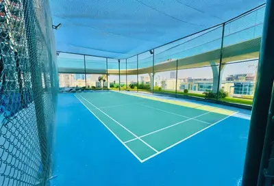 an indoor tennis court with a view of the city at HAVN - 1 Bedroom in Skyz, 5 mins to Miracle Garden in Dubai