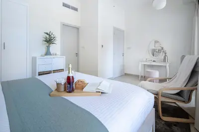 a white bedroom with a bed with a tray on it at Frank Porter - Bahar 6 in Dubai