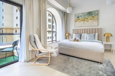 a bedroom with a bed and a chair and a window at Frank Porter - Bahar 6 in Dubai