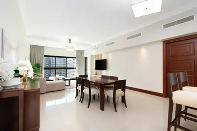 a dining room and living room with a table and chairs at Walnut Palm 2BR - Palm Jumeirah in Dubai