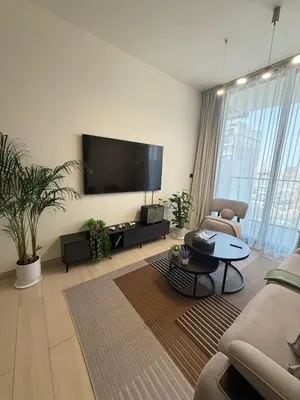 a living room with a large flat screen tv at Modern 1BR in JVC, Pool & Gym Near Circle Mall in Dubai