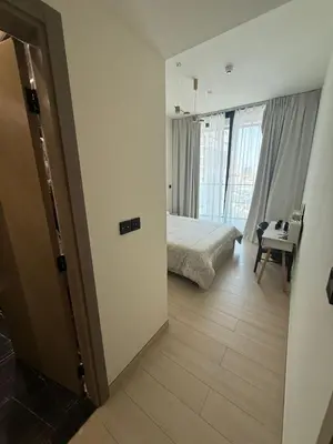 a bedroom with a bed and a room with a table at Modern 1BR in JVC, Pool & Gym Near Circle Mall in Dubai