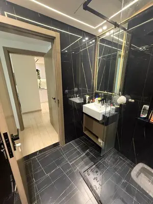 a black bathroom with a sink and a mirror at Modern 1BR in JVC, Pool & Gym Near Circle Mall in Dubai