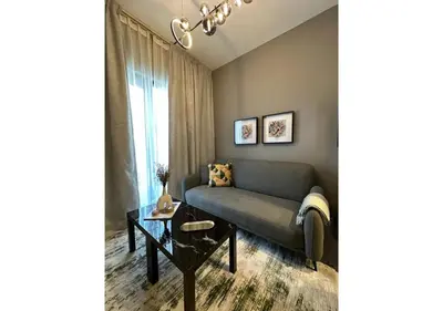 a living room with a couch and a table at KeyRock Living - Modern 1BR at Zada Tower with Pool and Gym Facilities in Dubai