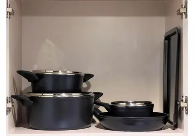 three pots and pans sitting on top of a stove at KeyRock Living - Modern 1BR at Zada Tower with Pool and Gym Facilities in Dubai