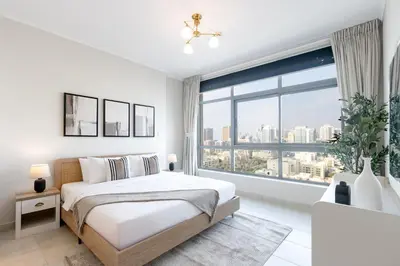 a bedroom with a bed and a large window at Stylish 1BR Retreat with Pool and Stunning City View in Dubai