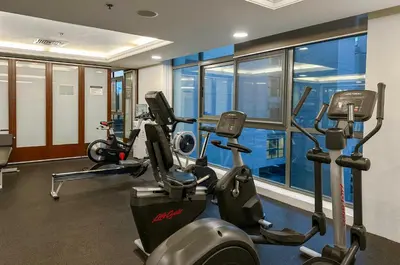 a gym with two treadmills and two ellipticals at Stylish 1BR Retreat with Pool and Stunning City View in Dubai