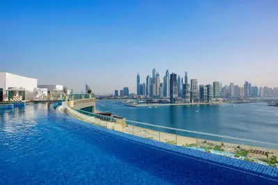 a large body of water with a city in the background at Seven Palm Elite 1BR-Infinity Pool & Skyline Views in Dubai
