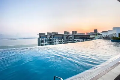a large swimming pool on the roof of a building at Seven Palm Elite 1BR-Infinity Pool & Skyline Views in Dubai