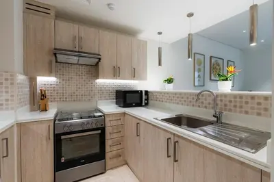 a kitchen with a sink and a stove at Stylish 1-BR Beachfront Apt on SEVEN PALM Dubai in Dubai
