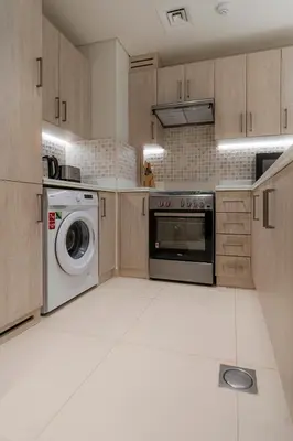 a kitchen with a washing machine and a washer at Stylish 1-BR Beachfront Apt on SEVEN PALM Dubai in Dubai