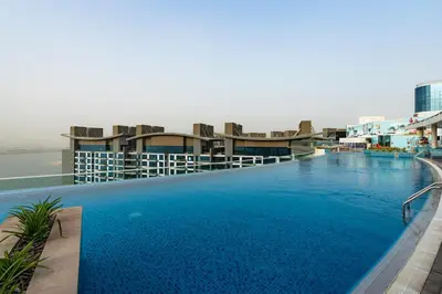a large swimming pool on top of a building at Stylish 1-BR Beachfront Apt on SEVEN PALM Dubai in Dubai