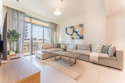 a living room with a couch and a table at Steps Away From JBR Beach And Marina Promenade, Quick Access To Palm Jumeirah, Surrounded by Leisure And Entertainment Hubs - Marina Vista Tower 2, Emaar Beachfront by Deluxe Holiday Homes in Dubai