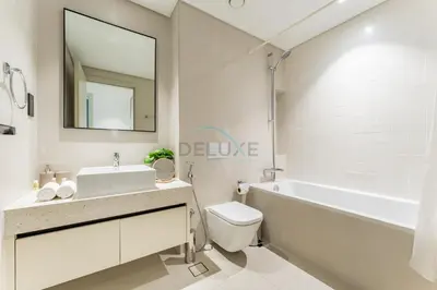 a bathroom with a sink and a tub and a toilet at Steps Away From JBR Beach And Marina Promenade, Quick Access To Palm Jumeirah, Surrounded by Leisure And Entertainment Hubs - Marina Vista Tower 2, Emaar Beachfront by Deluxe Holiday Homes in Dubai