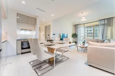 a living room with a table and a couch at Steps Away From JBR Beach And Marina Promenade, Quick Access To Palm Jumeirah, Surrounded by Leisure And Entertainment Hubs - Marina Vista Tower 2, Emaar Beachfront by Deluxe Holiday Homes in Dubai