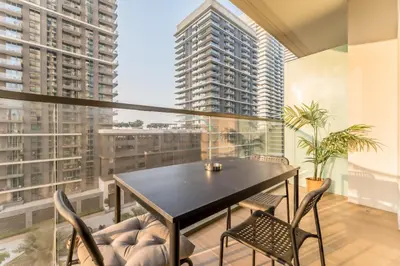 a dining room with a table and chairs and large windows at Steps Away From JBR Beach And Marina Promenade, Quick Access To Palm Jumeirah, Surrounded by Leisure And Entertainment Hubs - Marina Vista Tower 2, Emaar Beachfront by Deluxe Holiday Homes in Dubai