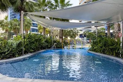 a large swimming pool with a white canopy and trees at Luxury Living at Paramount Tower B, Business Bay in Dubai