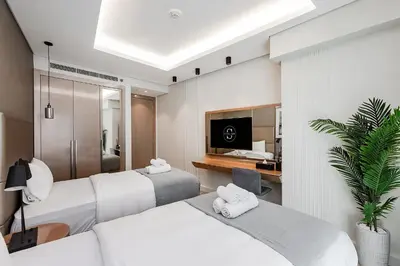 a hotel room with three beds and a desk at Luxury Living at Paramount Tower B, Business Bay in Dubai